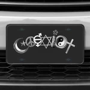 A close up of the Coexist front license plate on a white car