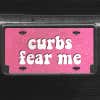 A close up of the Curbs Fear Me front license plate on a black car