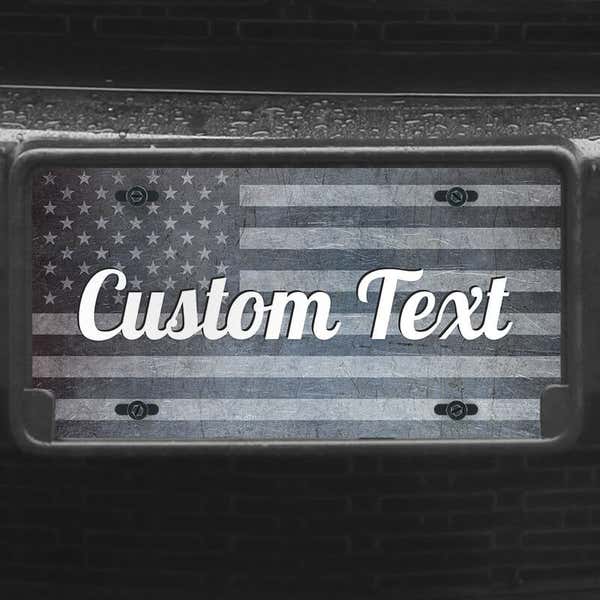 A close up of the Custom American Flag front license plate on a black car