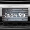 A close up of the Custom American Flag front license plate on a white car