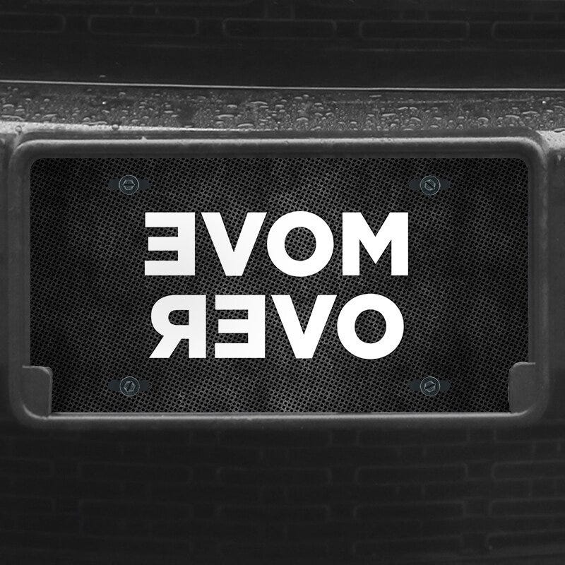 A close up of the Move Over front license plate on a black car