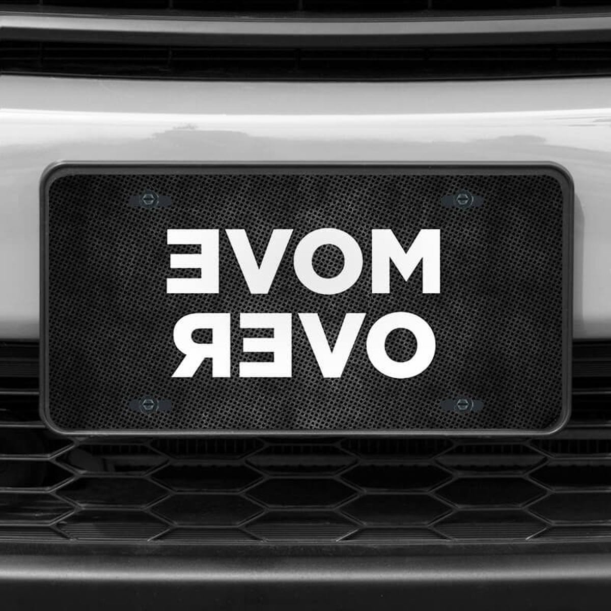 A close up of the Move Over front license plate on a white car