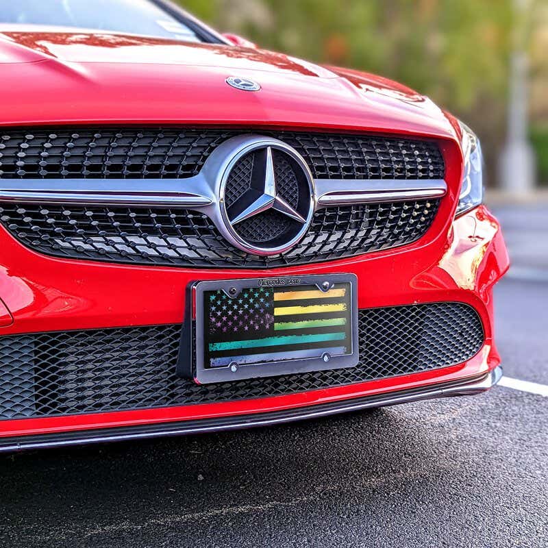 LGBTQ Pride American Flag front license plate on a red car