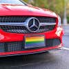 LGBTQ Pride front license plate on a red car