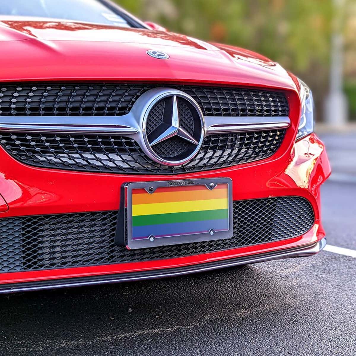 LGBTQ Pride front license plate on a red car