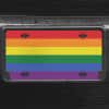 A close up of the LGBTQ Pride front license plate on a black car