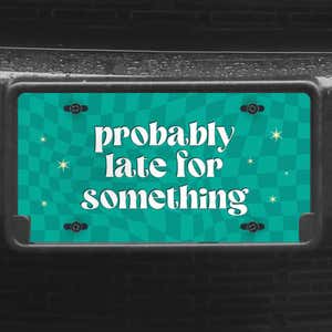 A close up of the Probably Late front license plate on a black car