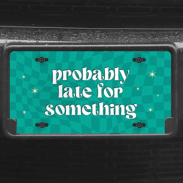 A close up of the Probably Late front license plate on a black car