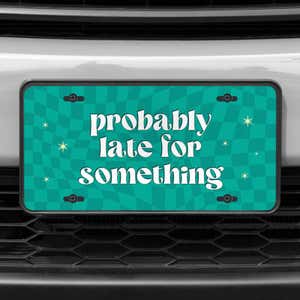 A close up of the Probably Late front license plate on a white car