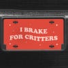 A close up of the I Brake For Critters front license plate on a black car