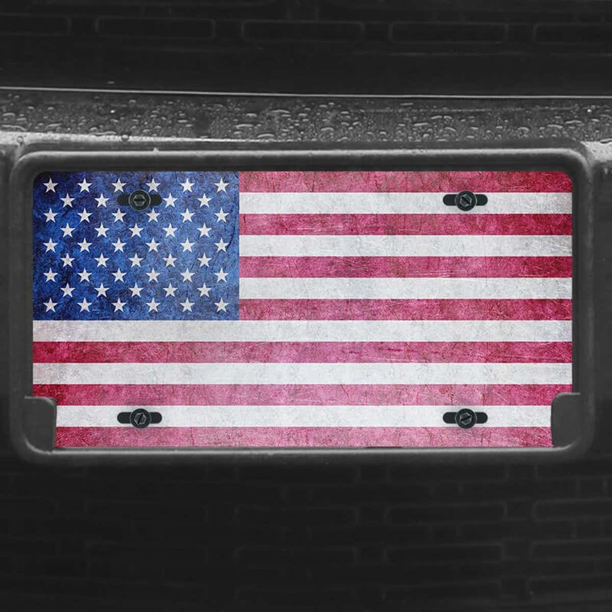 A close up of the American Flag Patriotic front license plate on a black car