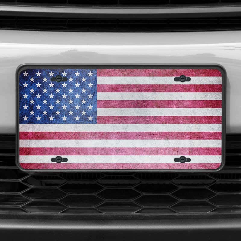 A close up of the American Flag Patriotic front license plate on a white car