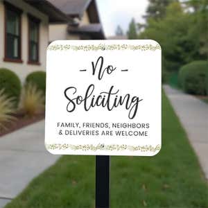 Pretty no soliciting sign, floral design with text on a yard stake in the front yard