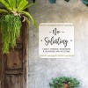 No soliciting sign, with a floral design on a white background, hung up on a wall saying family and friends are welcome