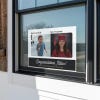 Baby photo graduation yard sign displayed in a window