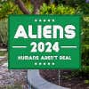 Aliens - Human Aren't Real Yard Sign Next to Pavement