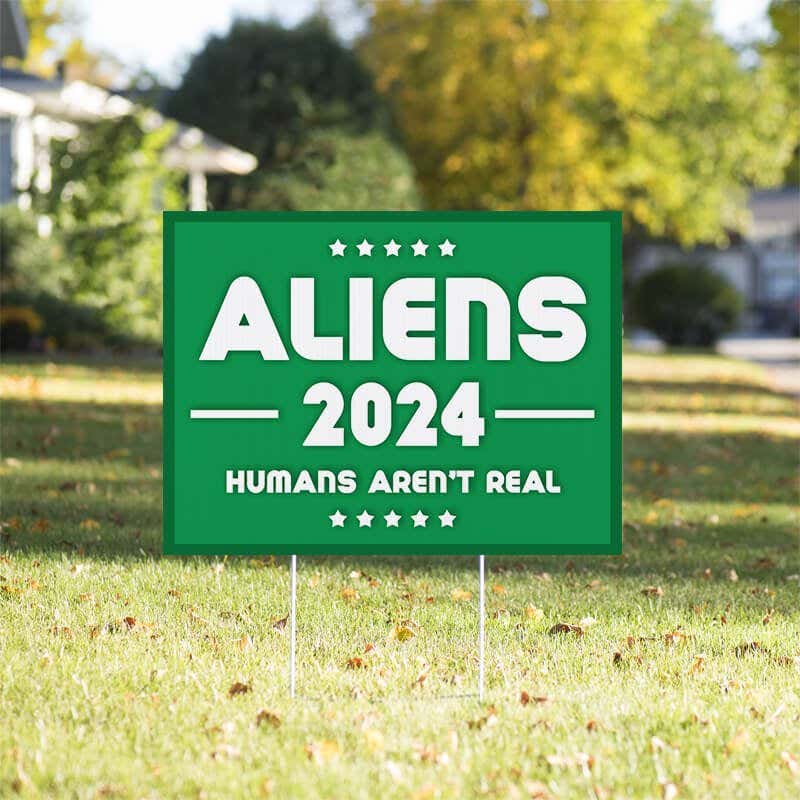 Aliens - Human Aren't Real Yard Sign in a Sunny Yard