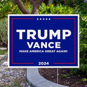 Trump Vance Blue Yard Sign next to pavement