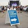 An event parking sandwich board for a music festival displayed in a parking lot