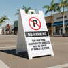 A no parking sandwich board placed in a parking space with a custom tow away zone message