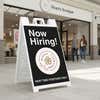 A now hiring sandwich board sign in front of a beauty boutique