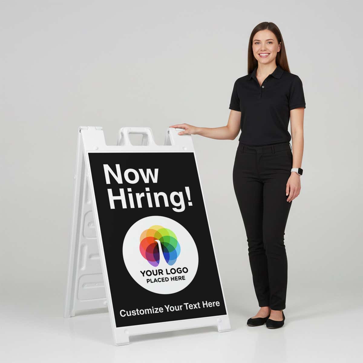 A woman standing next to an A-frame sign with her hand on the top of the sign