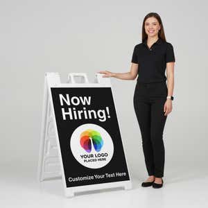 A woman standing next to an A-frame sign with her hand on the top of the sign