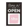 A sandwich board sign for a boutique that says We Are Open and features their logo