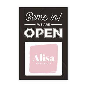A sandwich board sign for a boutique that says We Are Open and features their logo