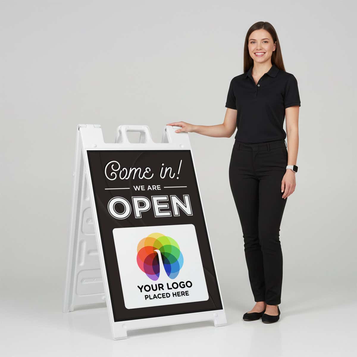 A woman standing next to an A-frame sign with her hand on the top of the sign