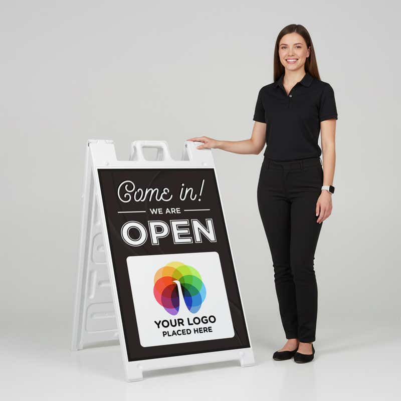 A woman standing next to an A-frame sign with her hand on the top of the sign