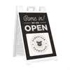 A sandwich board sign for a farmhouse that says We Are Open and features their logo
