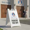 A sandwich board sign that says Parking This Way for a church