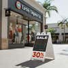 A 30% off sale sandwich board sign outside in front of a store