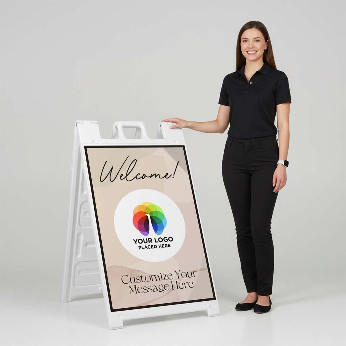 A woman standing next to a Welcome A-frame sign with her hand on the top of the sign