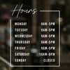 Modern business hours decal displayed on a store window