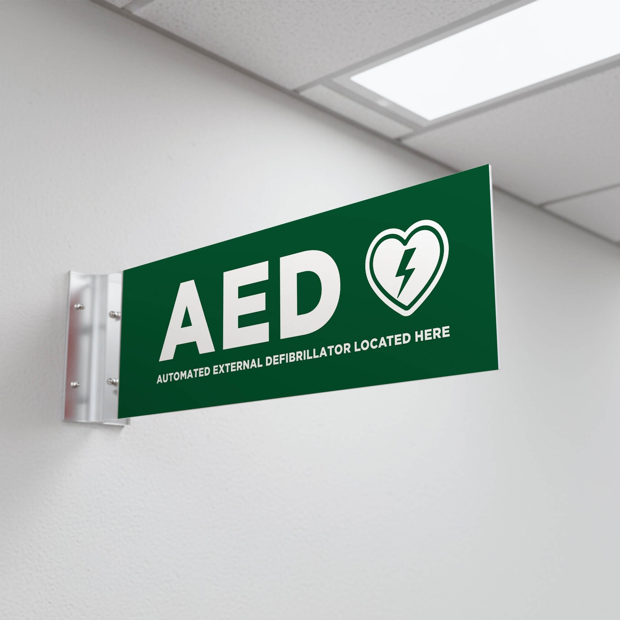 The green projecting AED sign in a hallway