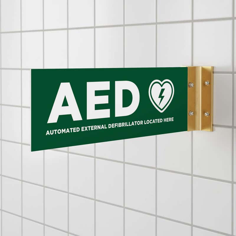 The green projecting AED sign in a bathroom