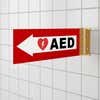 Red projecting AED sign in a bathroom
