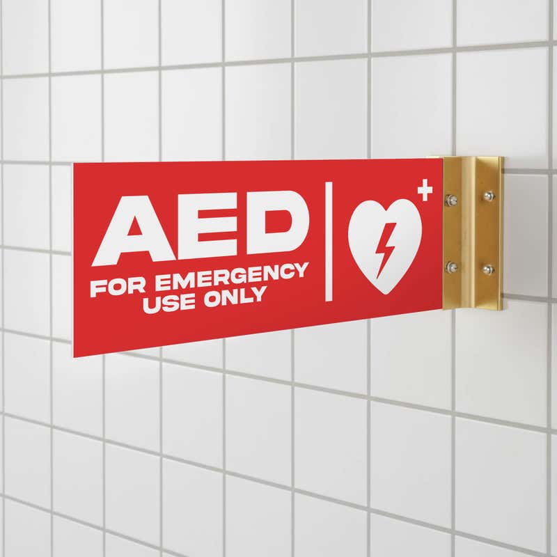 The red projecting AED sign in a bathroom