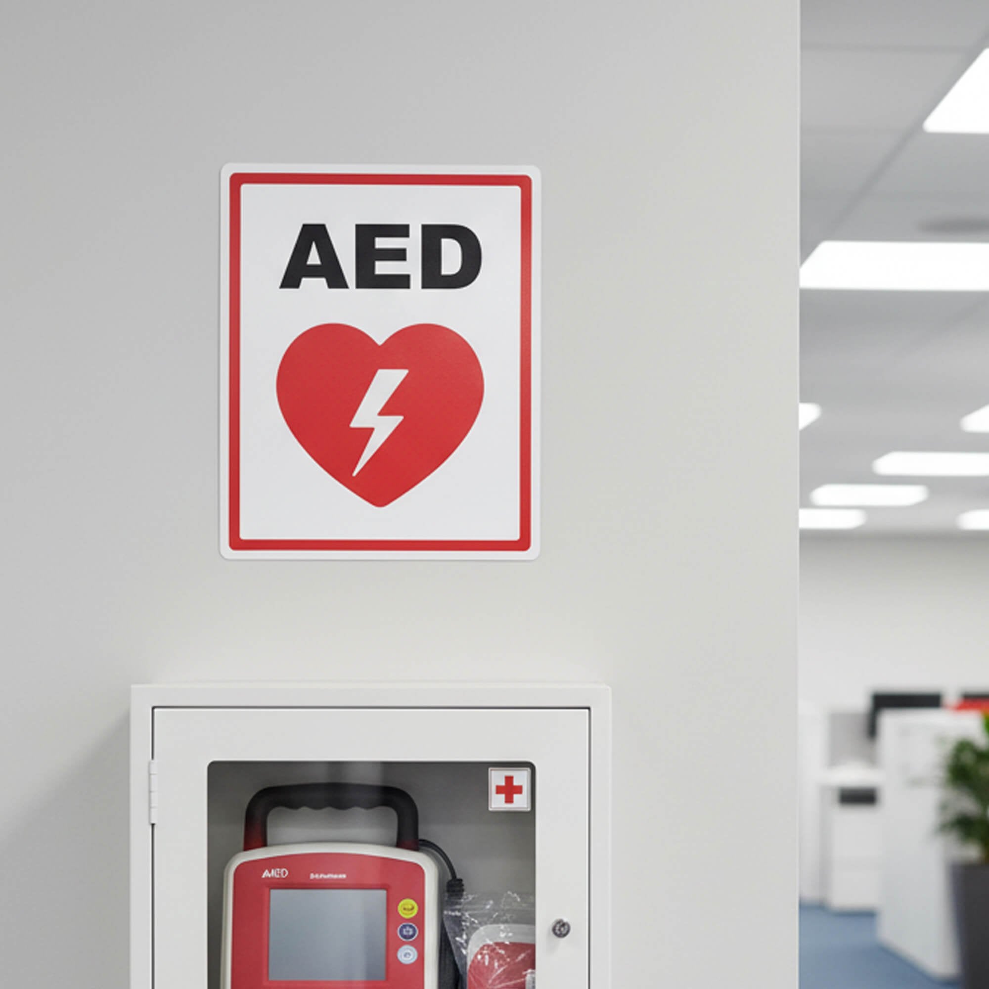 An AED sign placed above the AED in a building