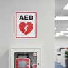 An AED sign placed above the AED in a building