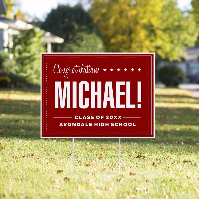 Bold name graduation yard sign displayed in a yard
