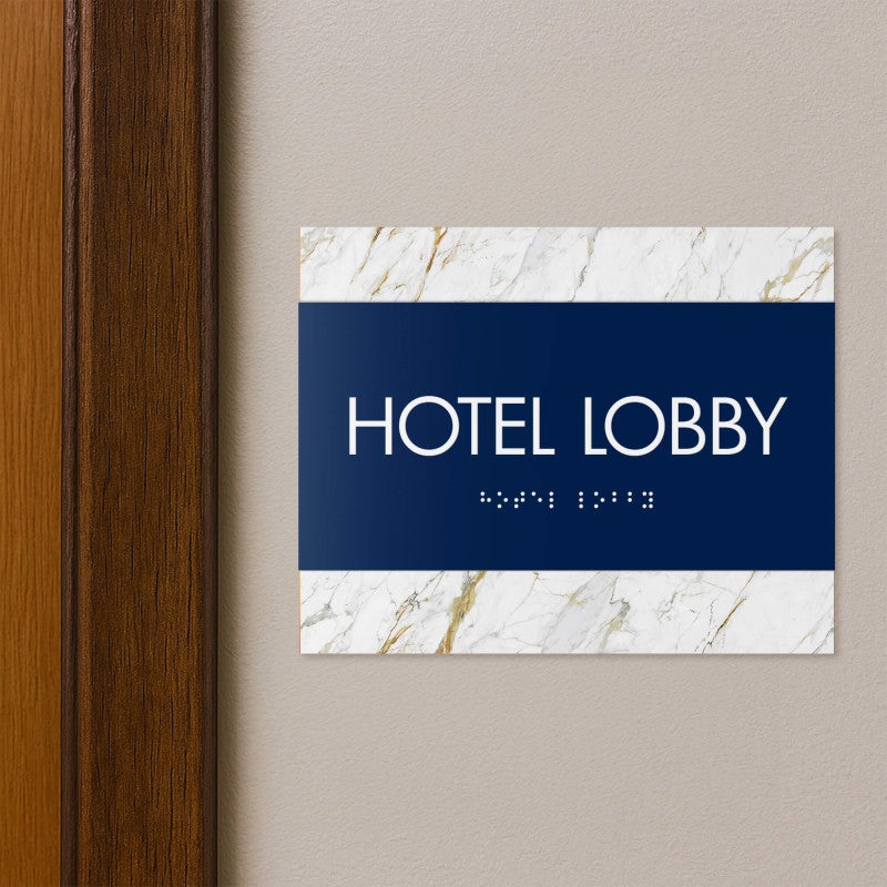 A 2-layered horizontal ADA sign for a hotel lobby with a blue foreground and white marble background