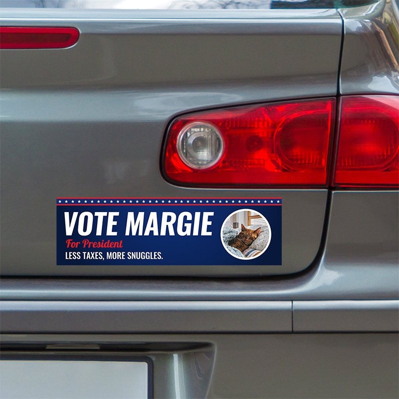 Custom Round Photo Political Bumper Sticker below a gray car's tail light