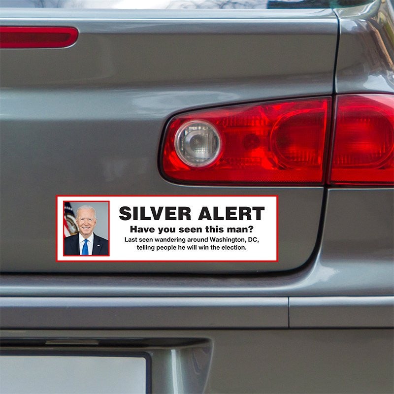 Silver Alert Political Bumper Sticker below a gray car's tail light