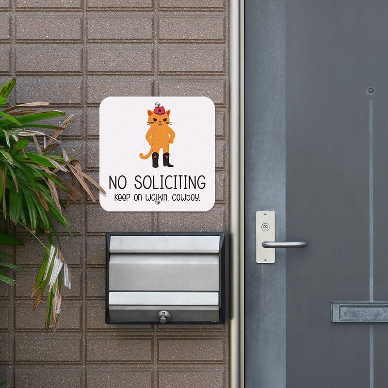 Cute orange cowboy cat no soliciting sign hung up next to the front door
