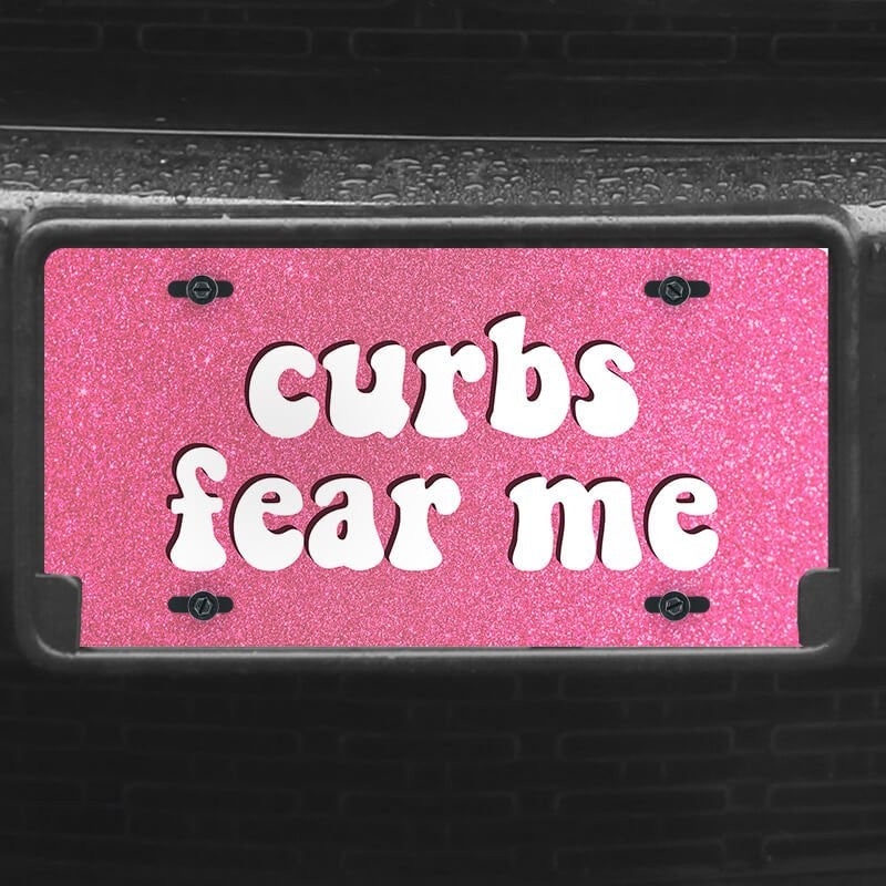 A close up of the Curbs Fear Me front license plate on a black car
