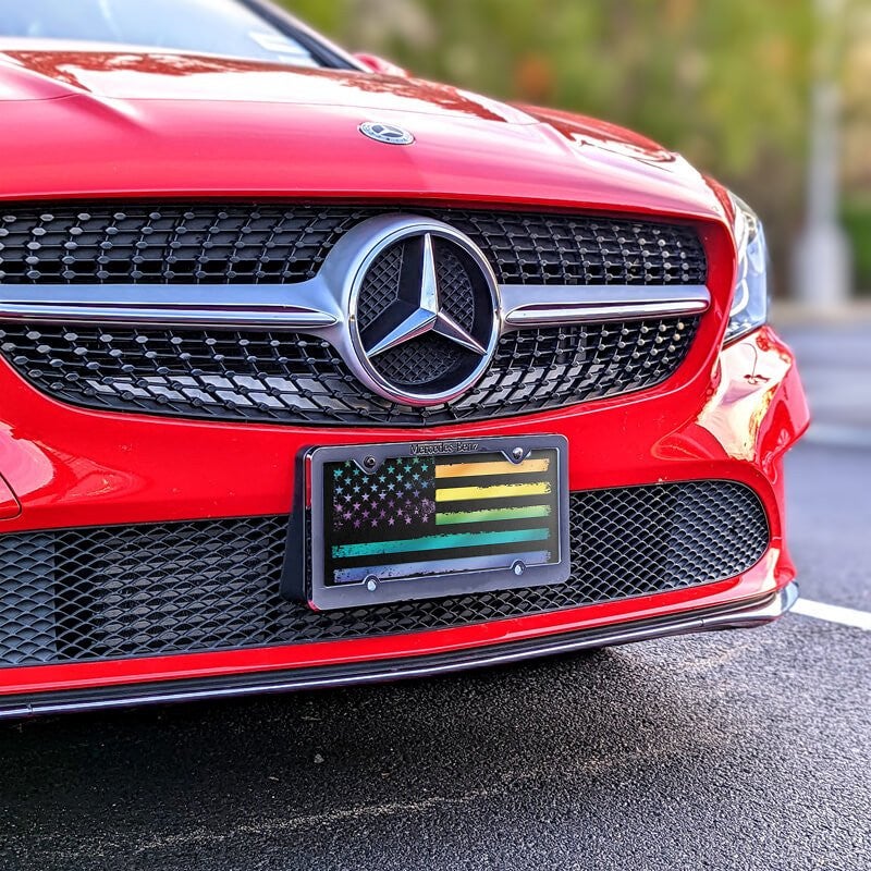 LGBTQ Pride American Flag front license plate on a red car