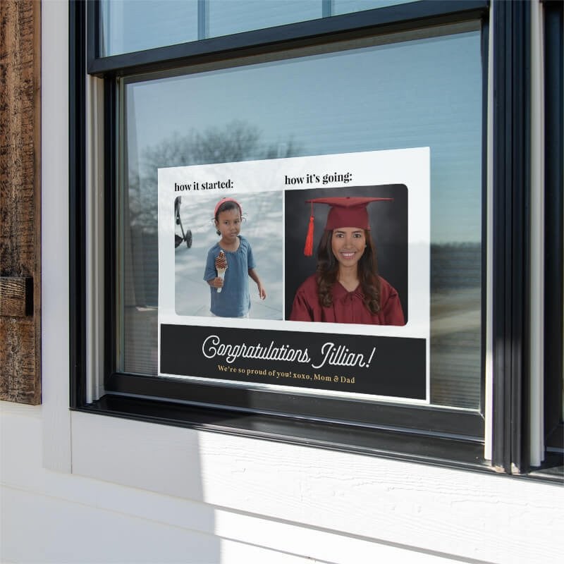 Baby photo graduation yard sign displayed in a window
